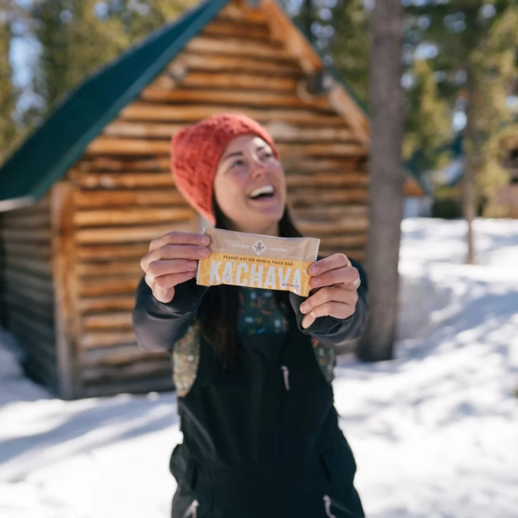 A happy young girl is holding Ka Chava Bars in winter.