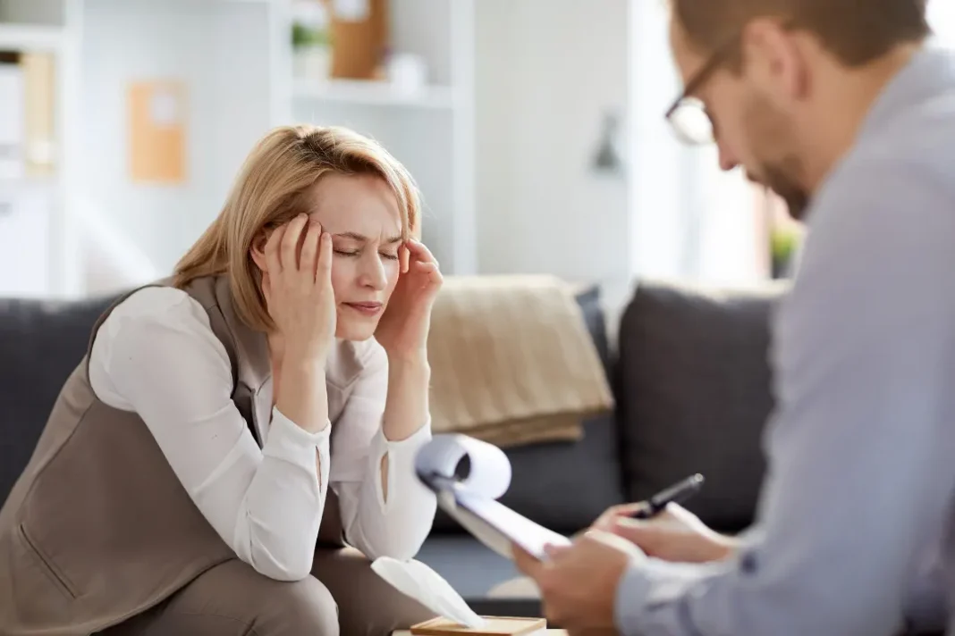 Doctor writing prescription for tensed woman