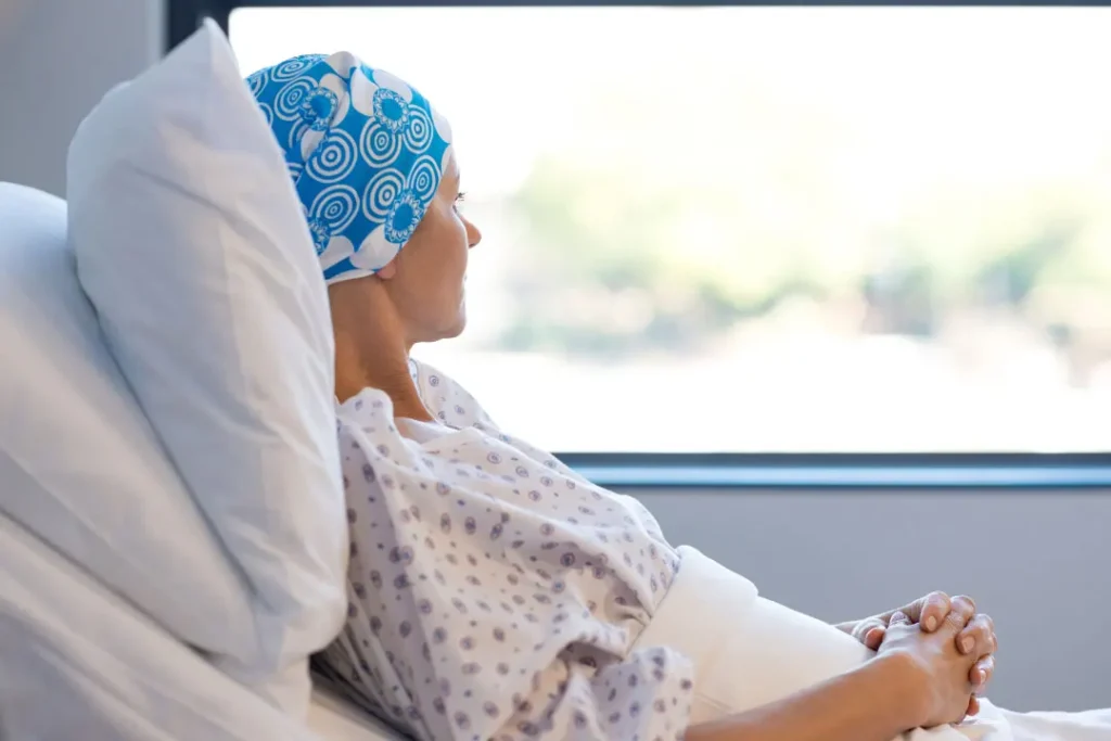 A woman having cancer looking outside the window. 