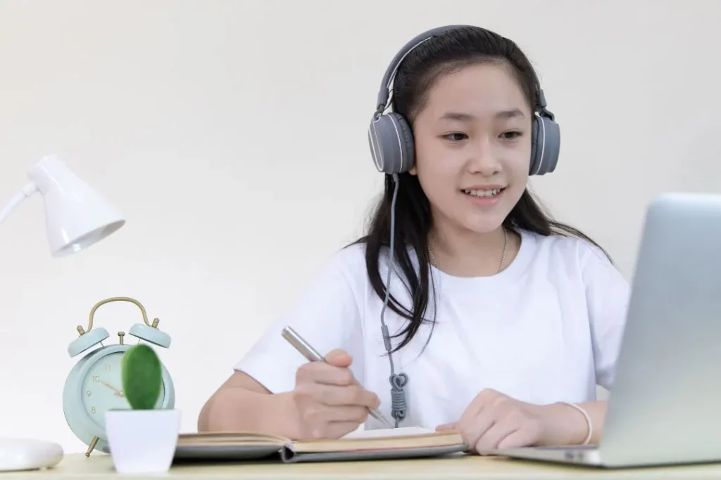 A young girl leaning on her laptop. 